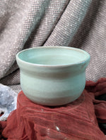 Mint green matcha tea bowl on a textured surface