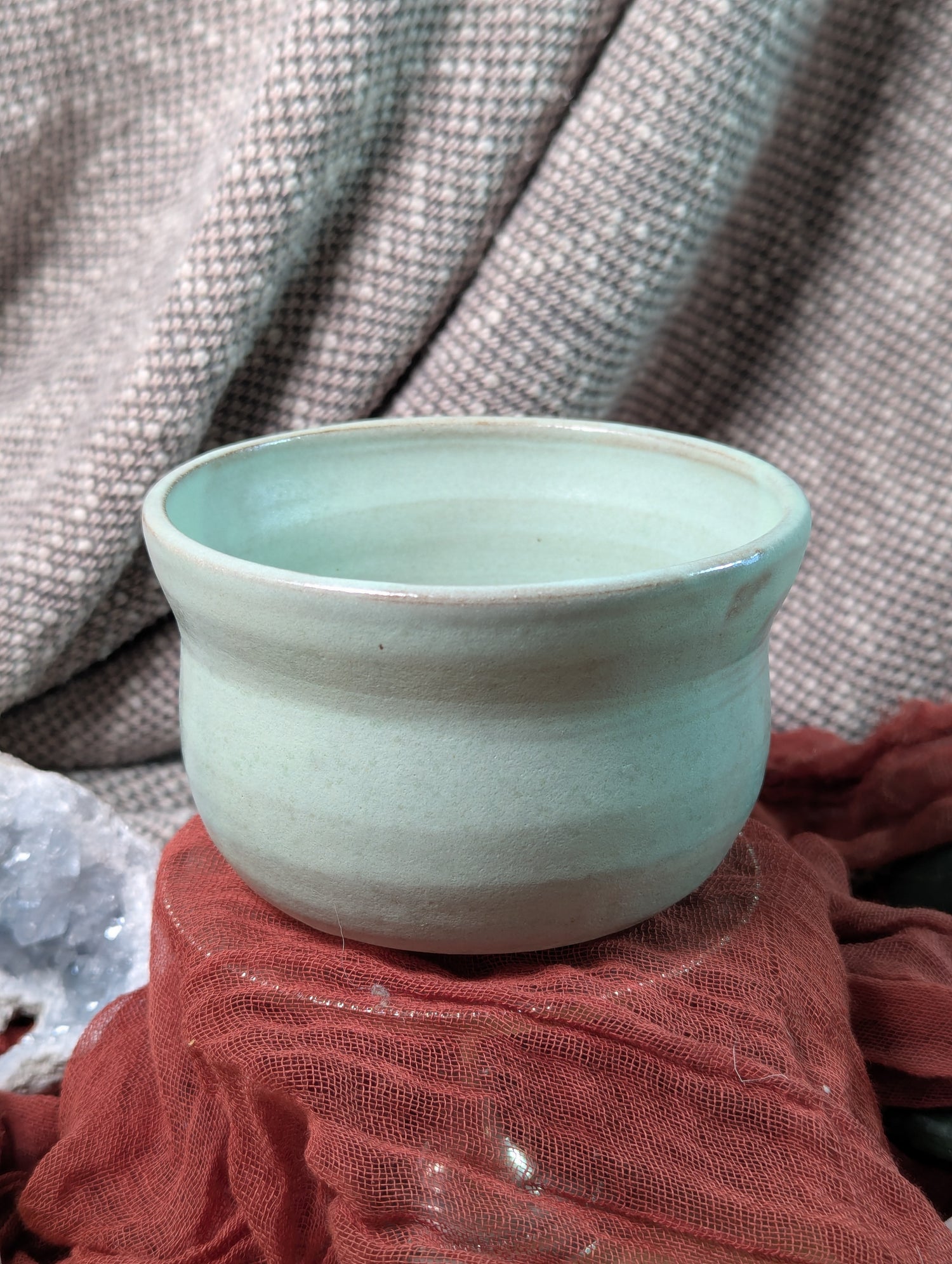 Mint green matcha tea bowl on a textured surface