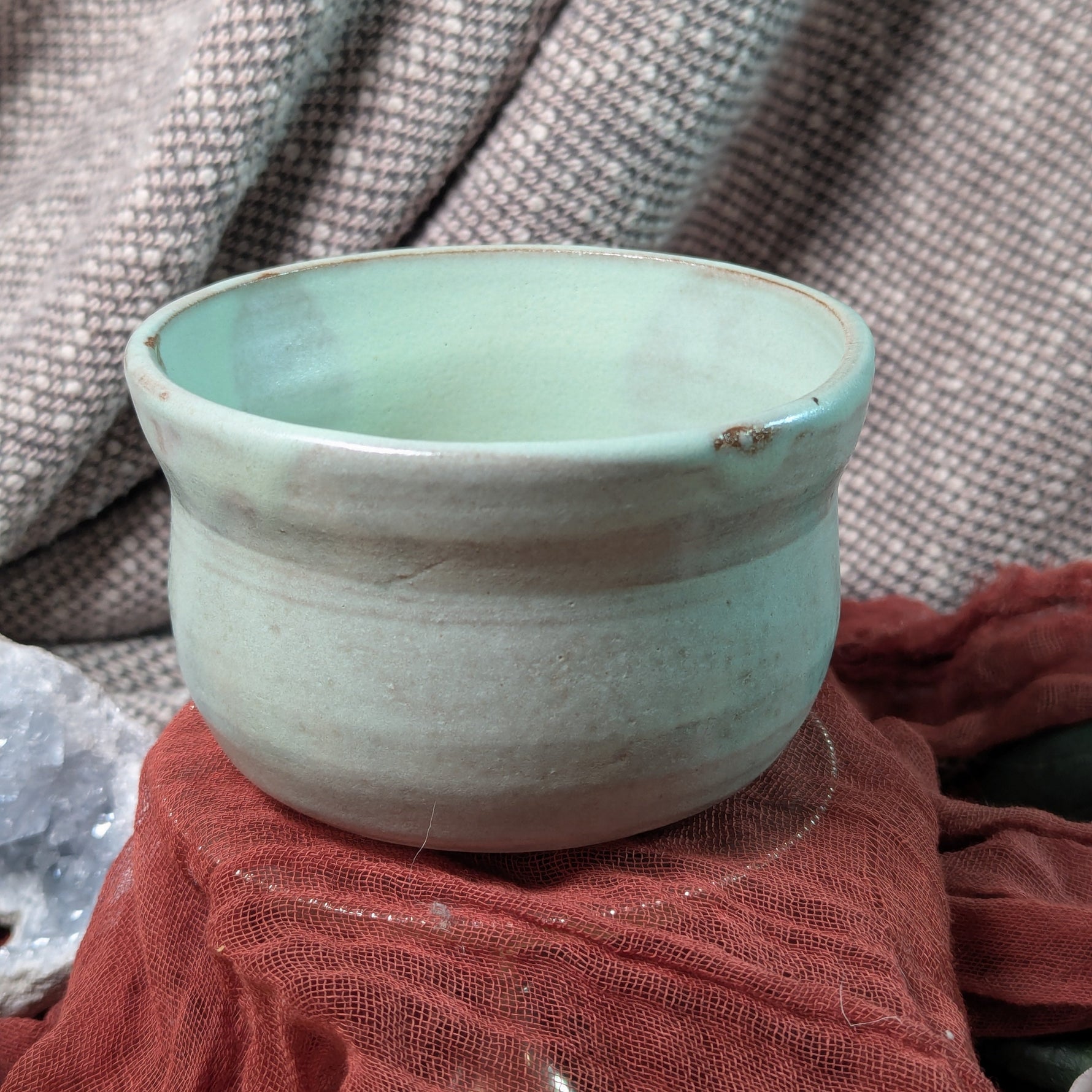 Mint green matcha tea bowl on a textured surface