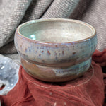 Ceramic bowl with a pearl glaze on a textured surface