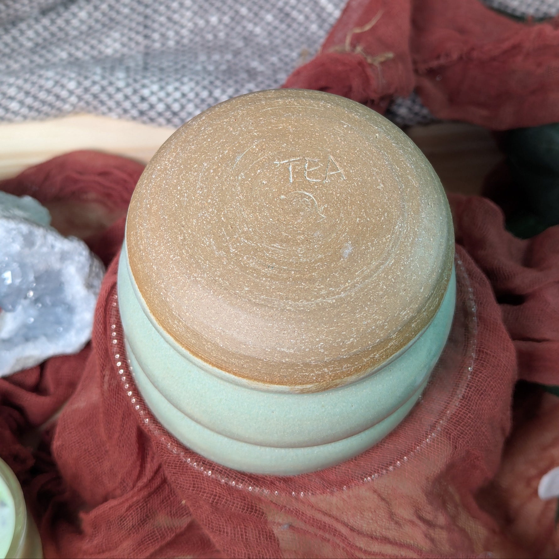Bottom of the Mint green ceramic tea cup with potter's signature on the bottom