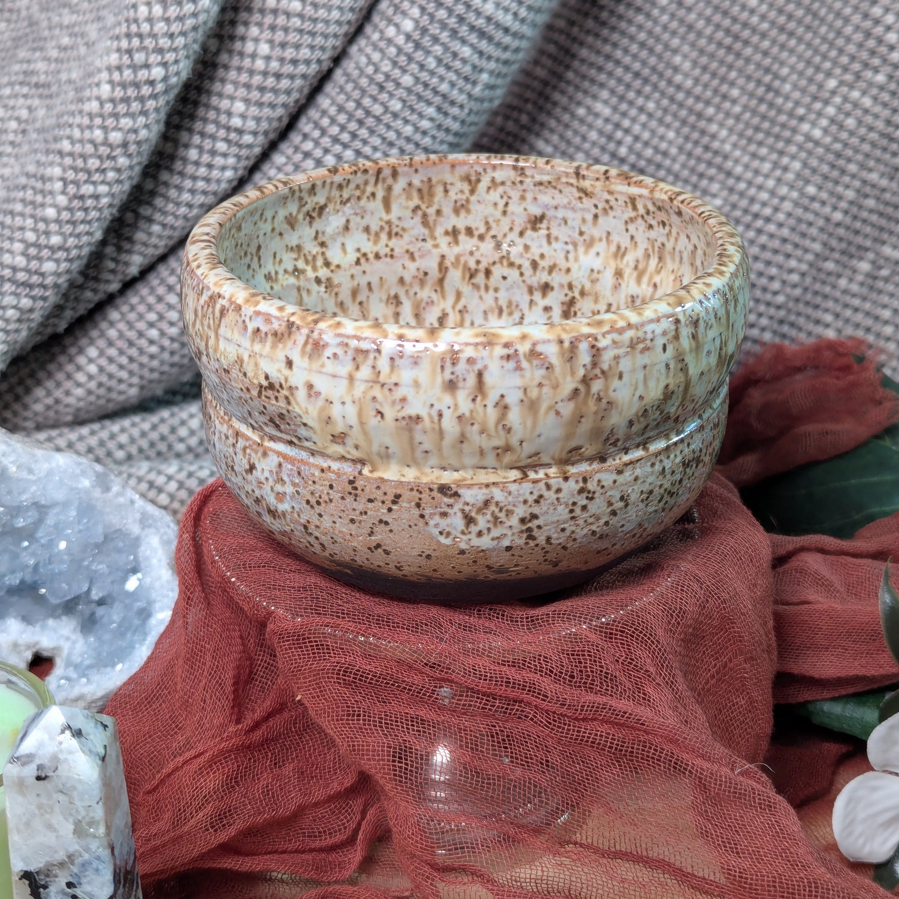 Speckled ceramic bowl on a textured surface with a blurred background