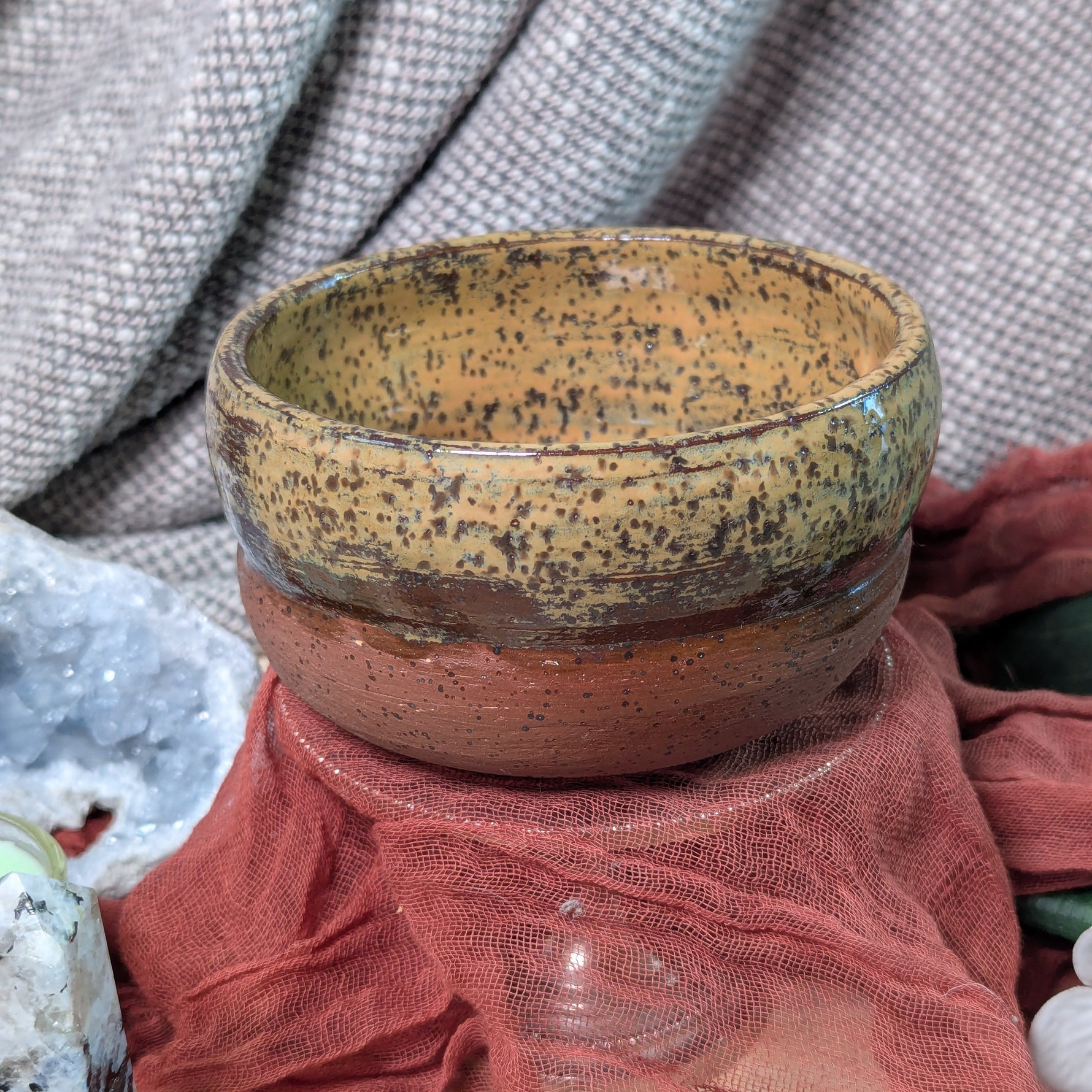 Ceramic bowl with speckled pattern on a textured surface