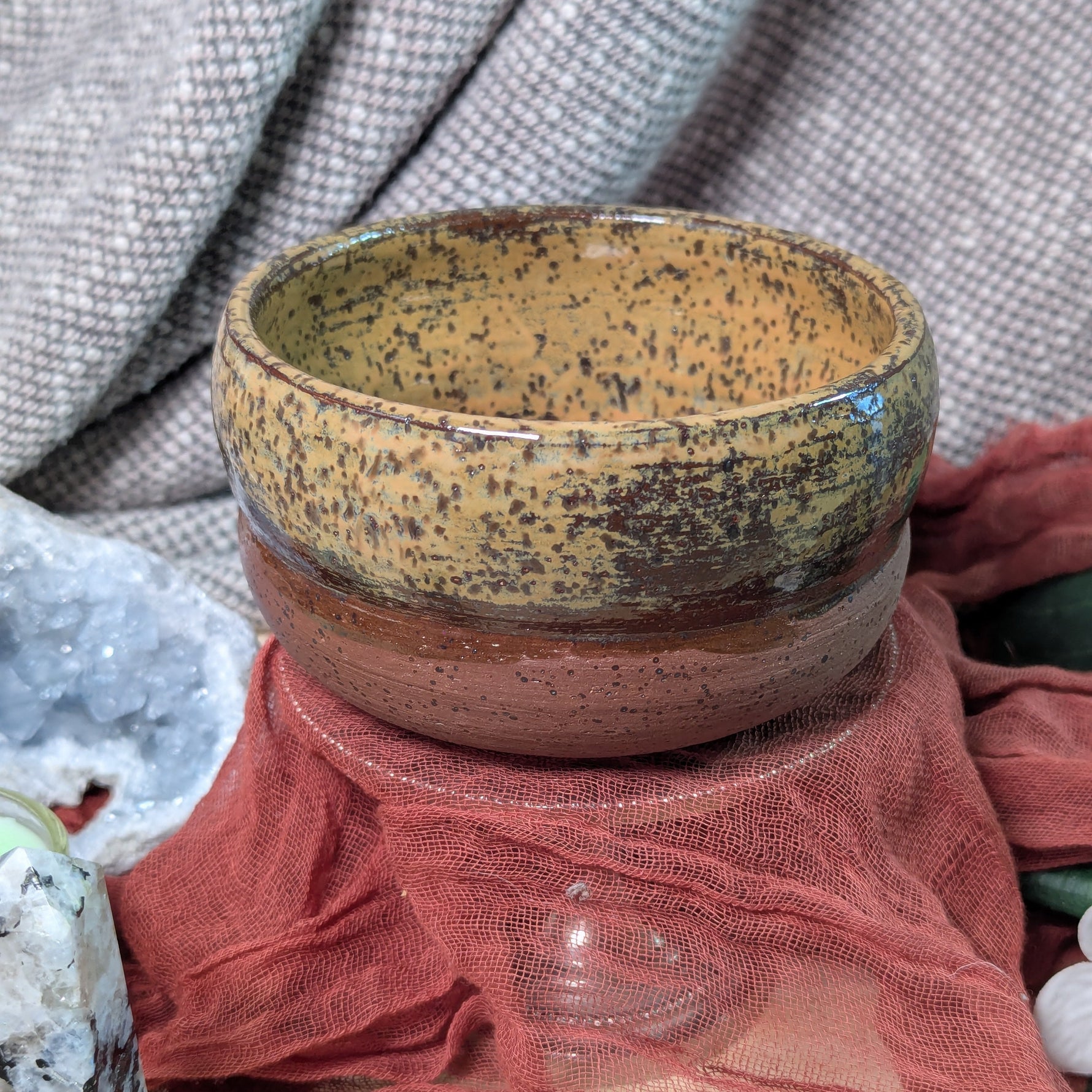 Ceramic bowl with speckled pattern on a textured surface